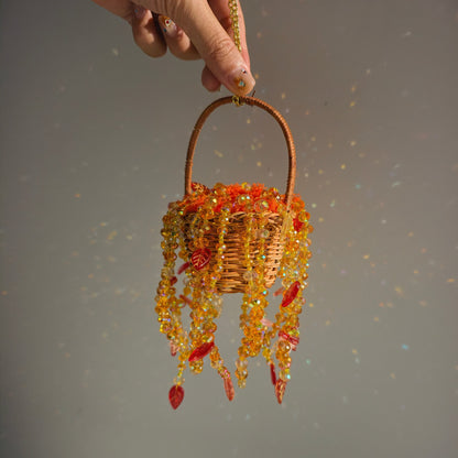 Handheld Autumn Dusk beaded basket showing its small scale and cascading autumn-colored strands