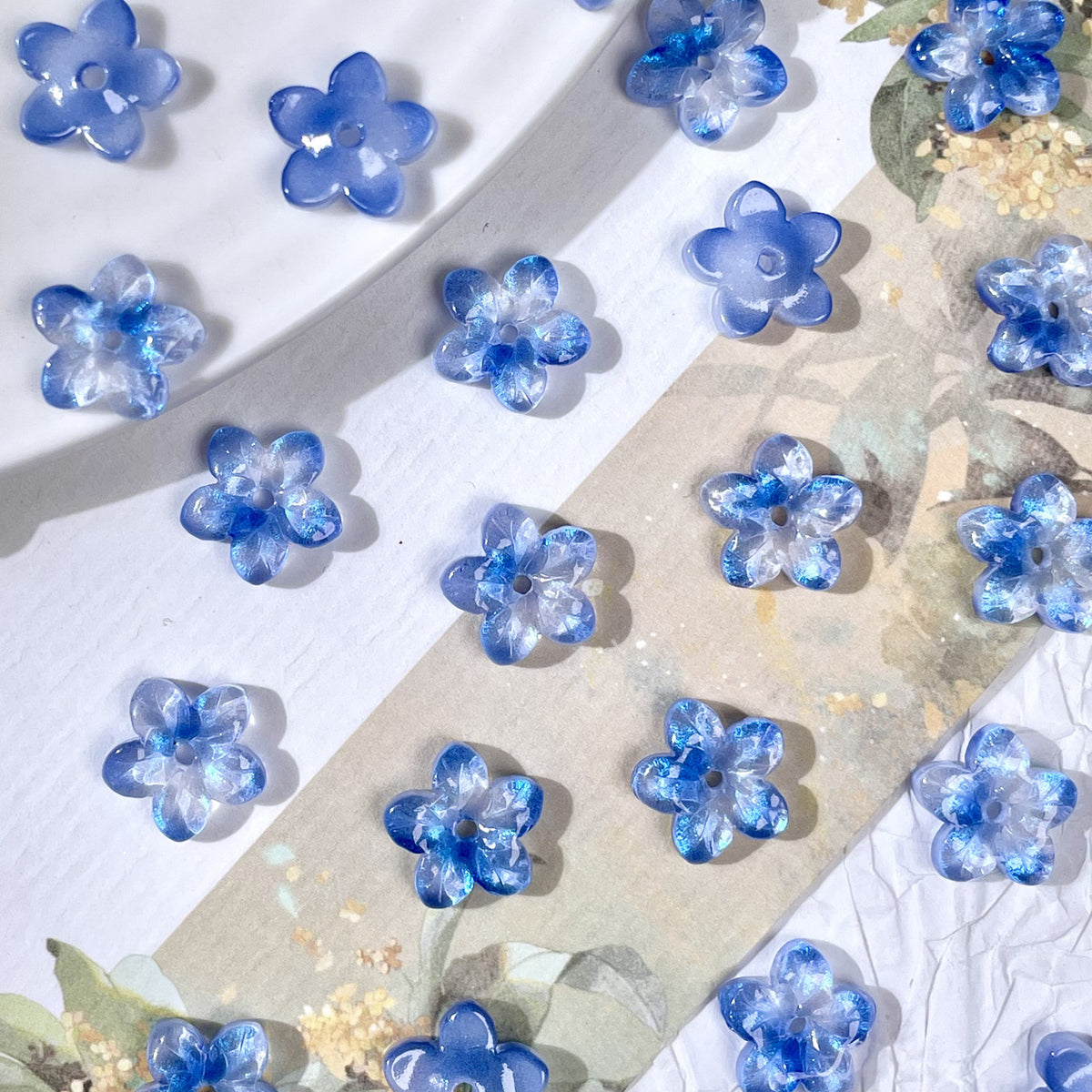 10mm five-petal glass flower beads in Iridescent Ice Blue, 50 pieces per pack