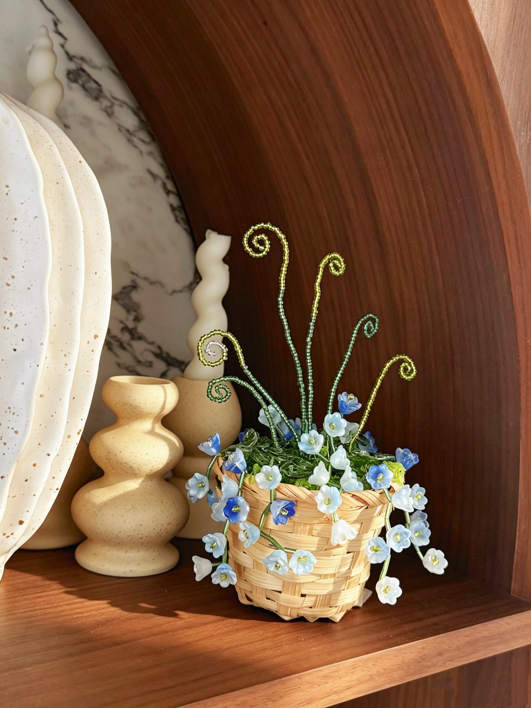 Blue and white beaded flower plant in a woven basket
