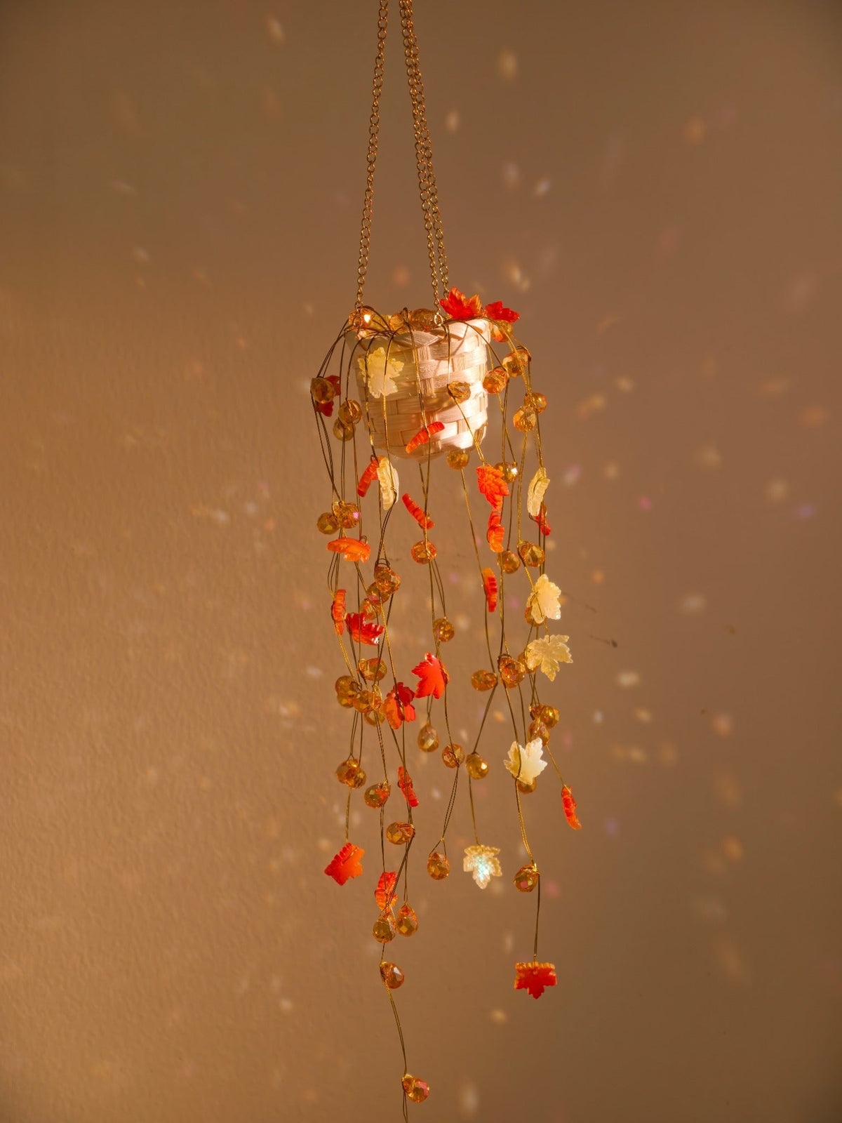 Amber and maple leaf beaded hanging plant in warm light