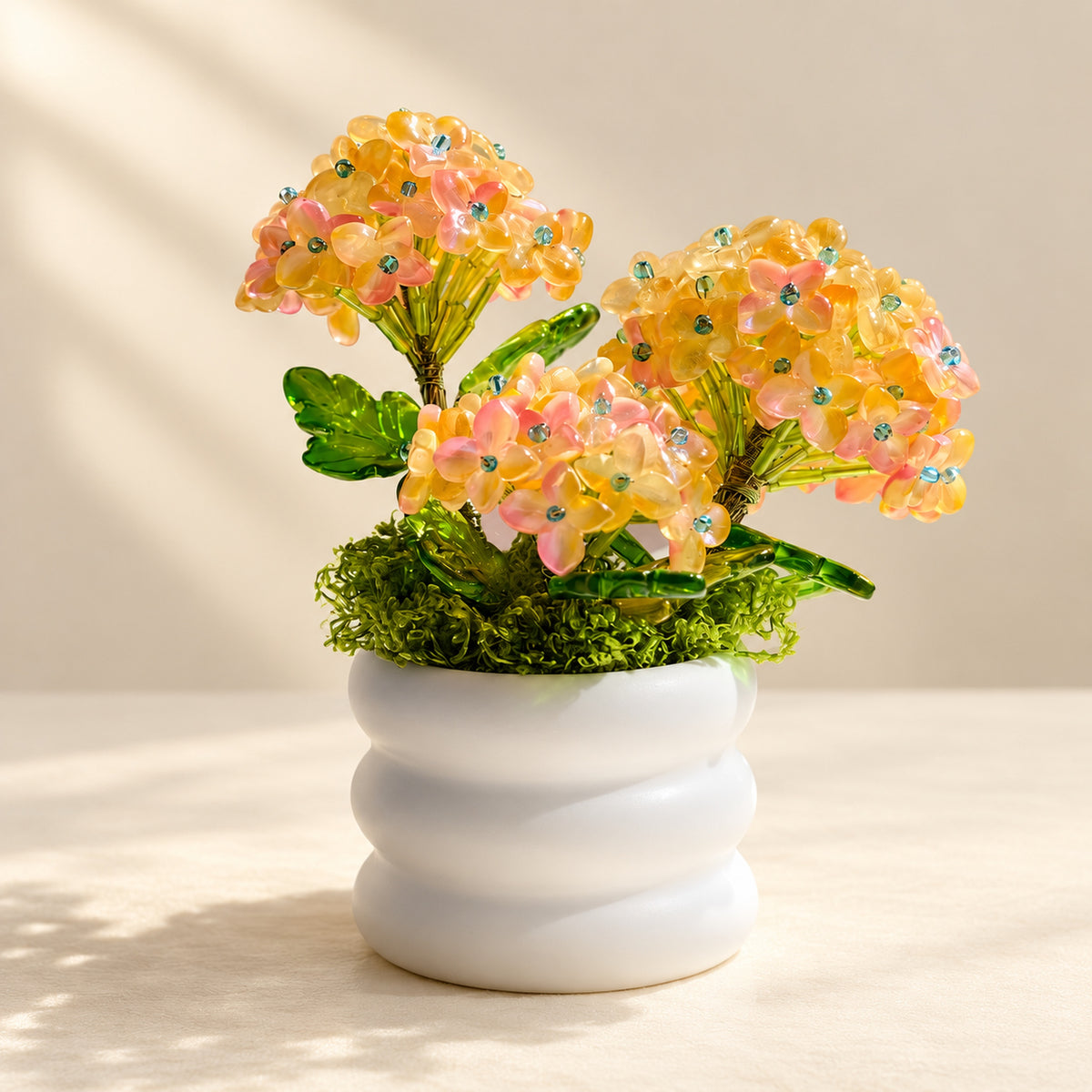 Pink and yellow beaded hydrangea in a white spiral pot.