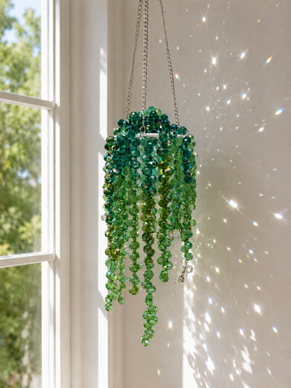 Finished extra-full green beaded hanging plant suncatcher in a white mini pot sparkling in sunlight