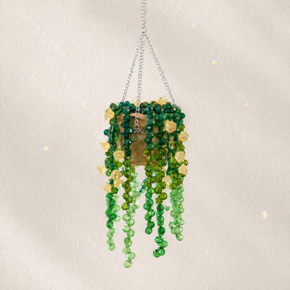 Cascading green beaded hanging plant with pale yellow flower beads and a silver chain