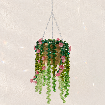 Cascading green beaded hanging plant with translucent rose pink flower beads and a silver chain