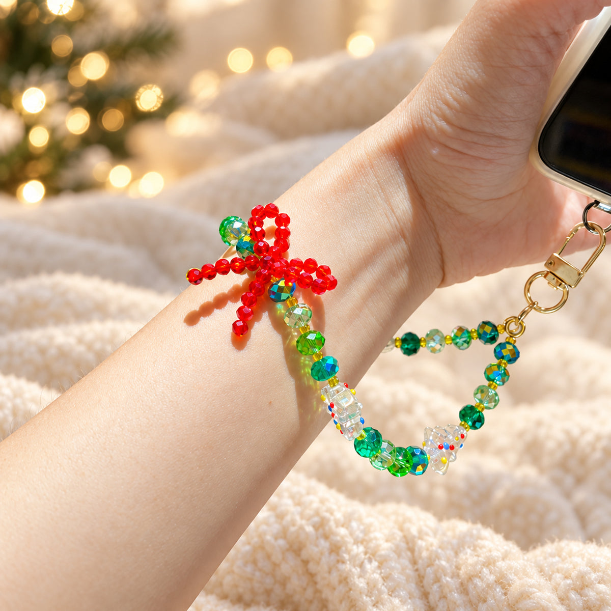 Detail of the red beaded bow and gold-tone clasp on the Christmas phone and bag charm