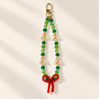 Christmas beaded phone and bag charm with green faceted beads, clear Christmas-tree beads, a red beaded bow and a gold-tone clasp