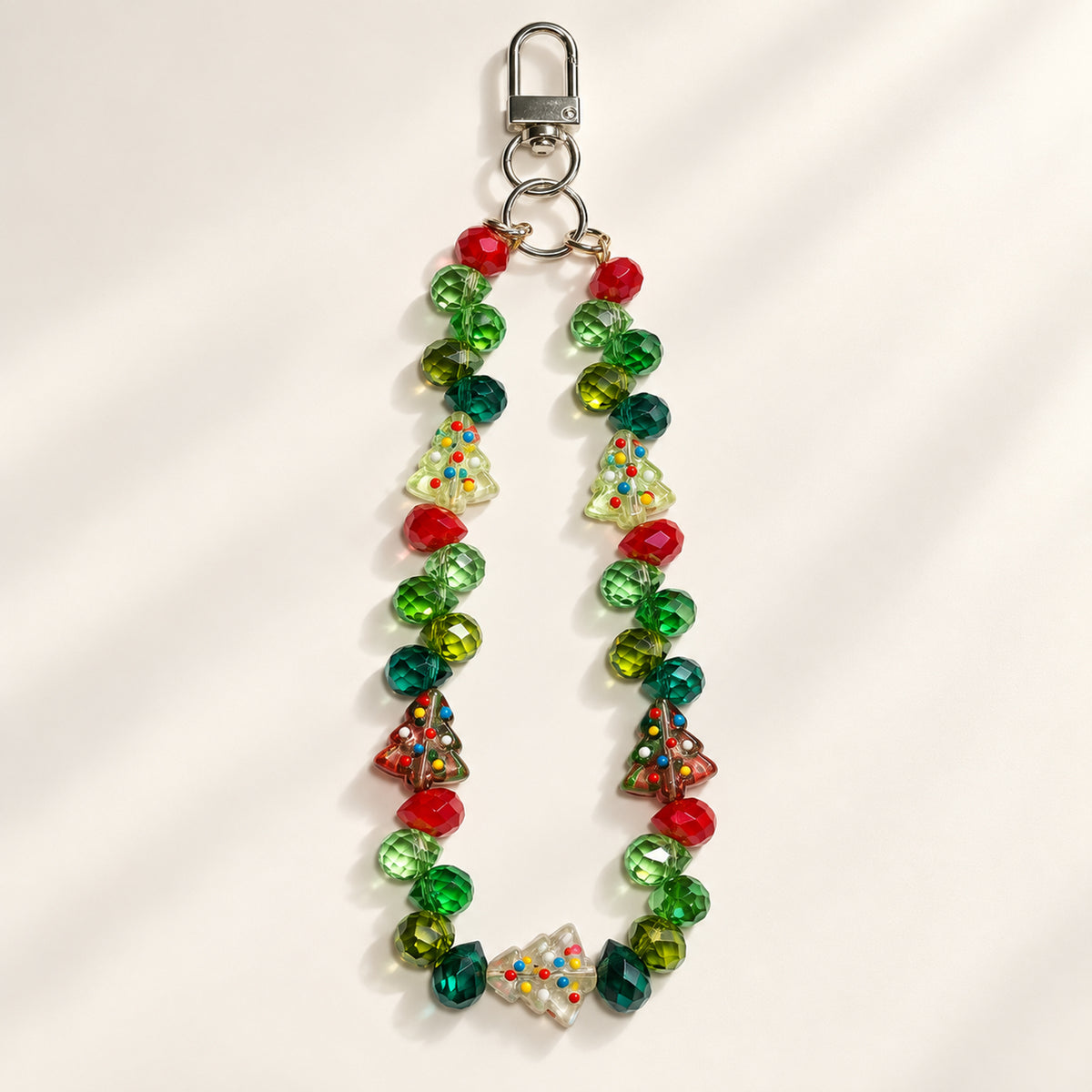 Christmas Tree design beaded phone and bag charm with green and red faceted beads, five tree-shaped beads and a silver-tone clasp