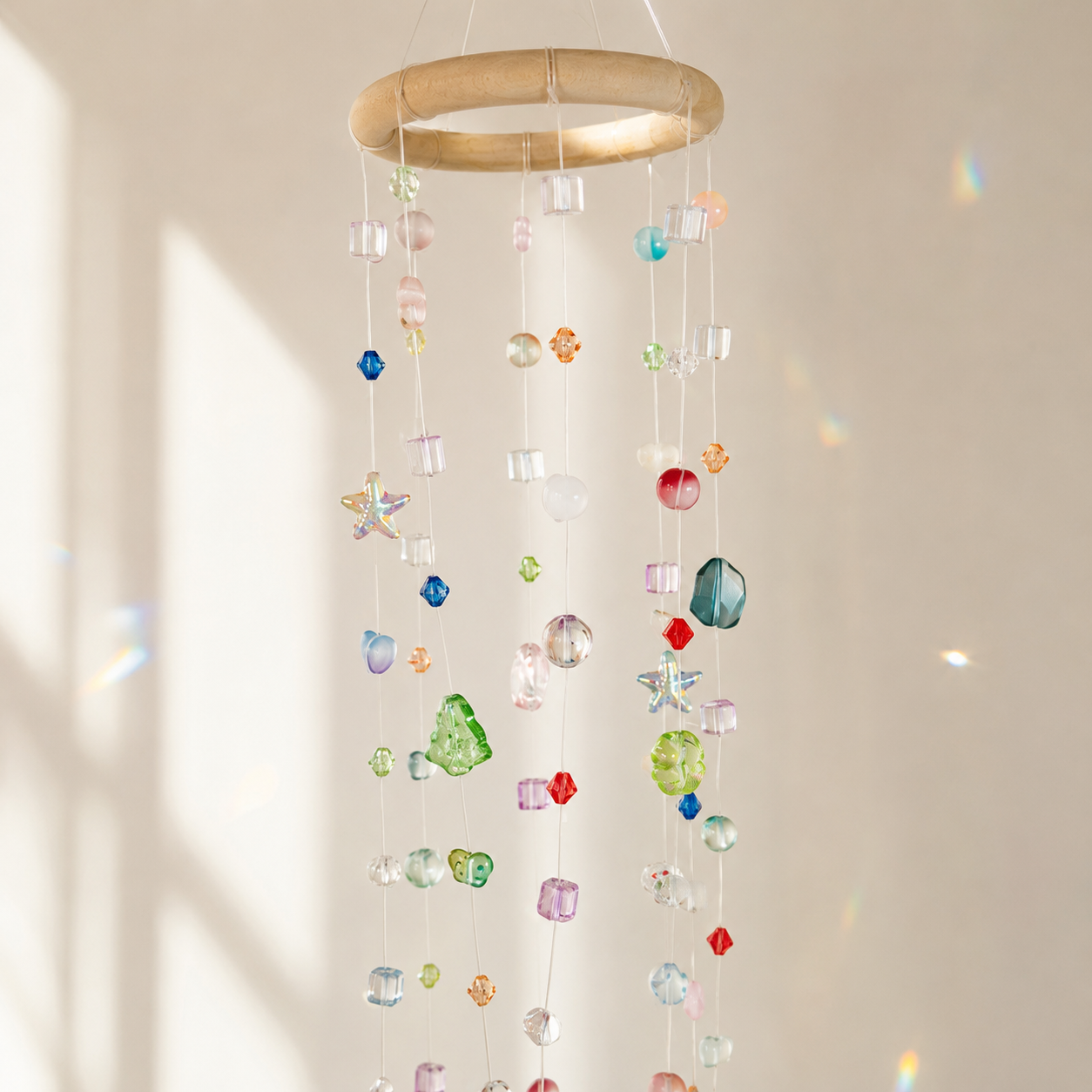 Close-up of mixed translucent beads and wrapped ring on a hanging mobile suncatcher
