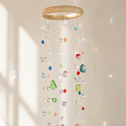 Close-up of mixed translucent beads and wrapped ring on a hanging mobile suncatcher