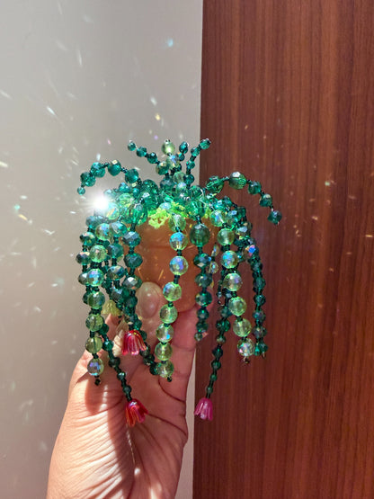 Handmade green beaded plant suncatcher with cascading vines and colorful flower beads sparkling in sunlight