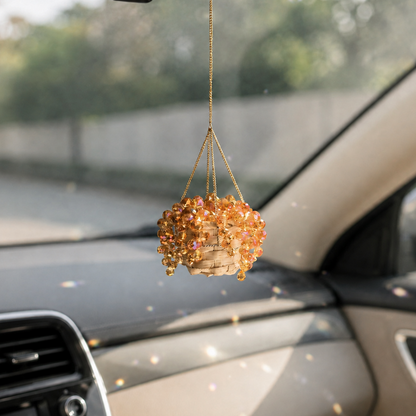 Golden Amber mini beaded plant car charm hanging inside a car with reflected light spots
