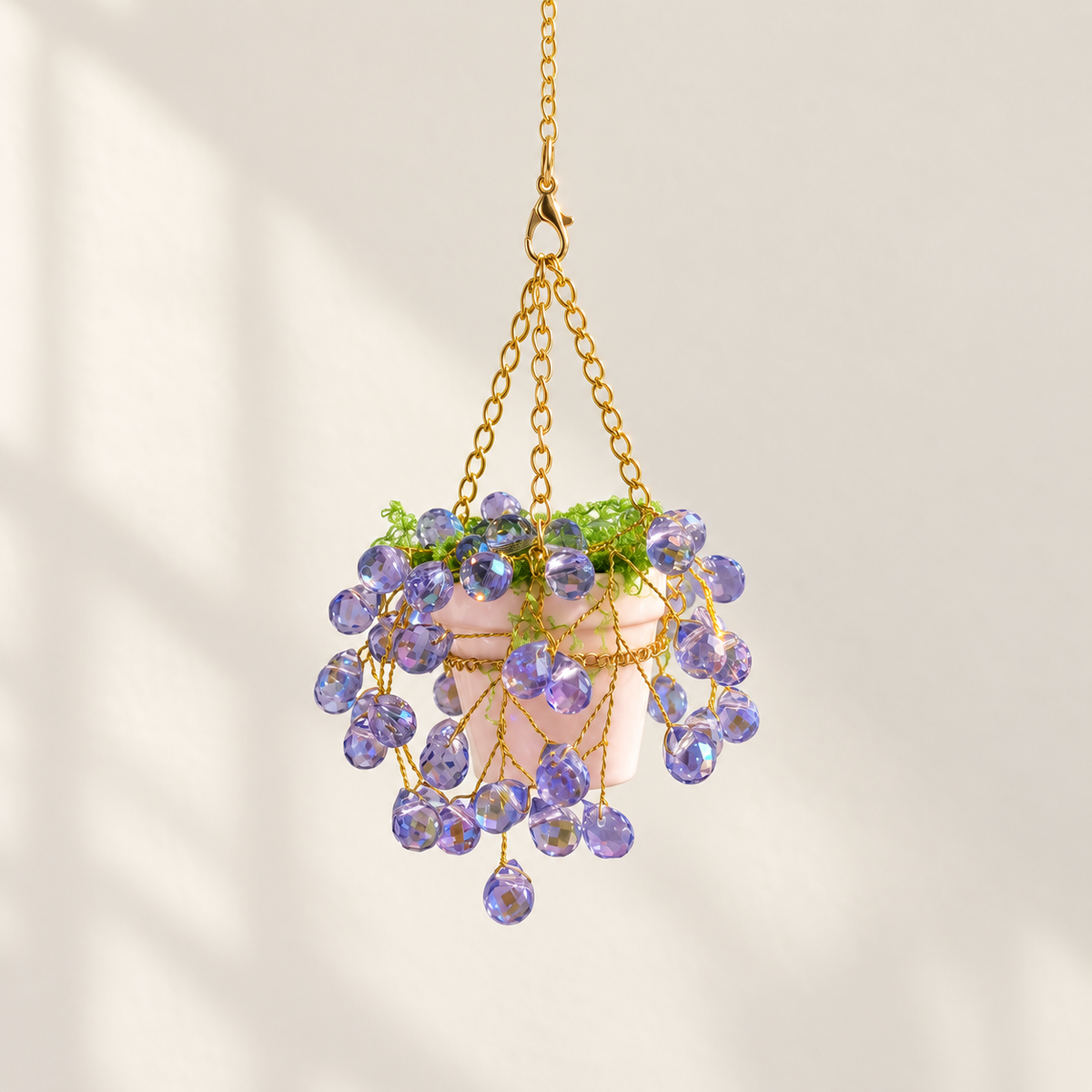 Mini purple beaded hanging plant with gold wire, green faux grass and a pale pink ceramic pot