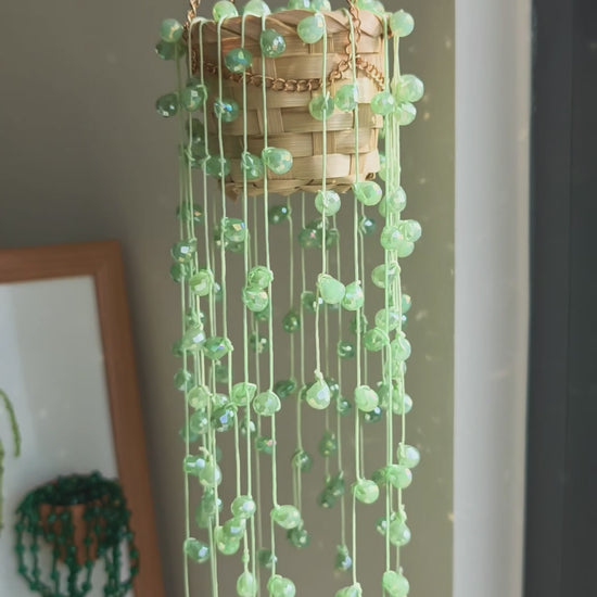 String of pearls beaded hanging plant with pale seafoam green bead strands on a gold chain