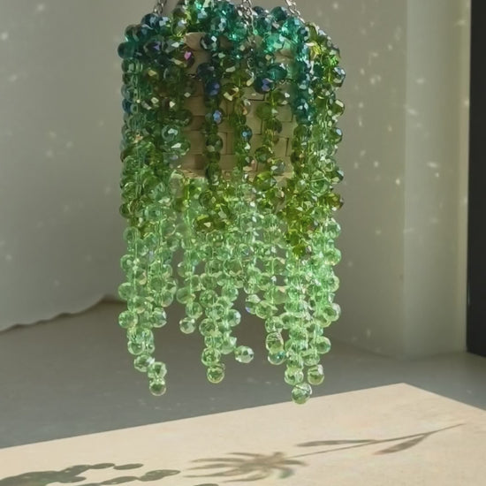 Extra-full beaded plant casting lace-like bead shadows across a sunlit wall