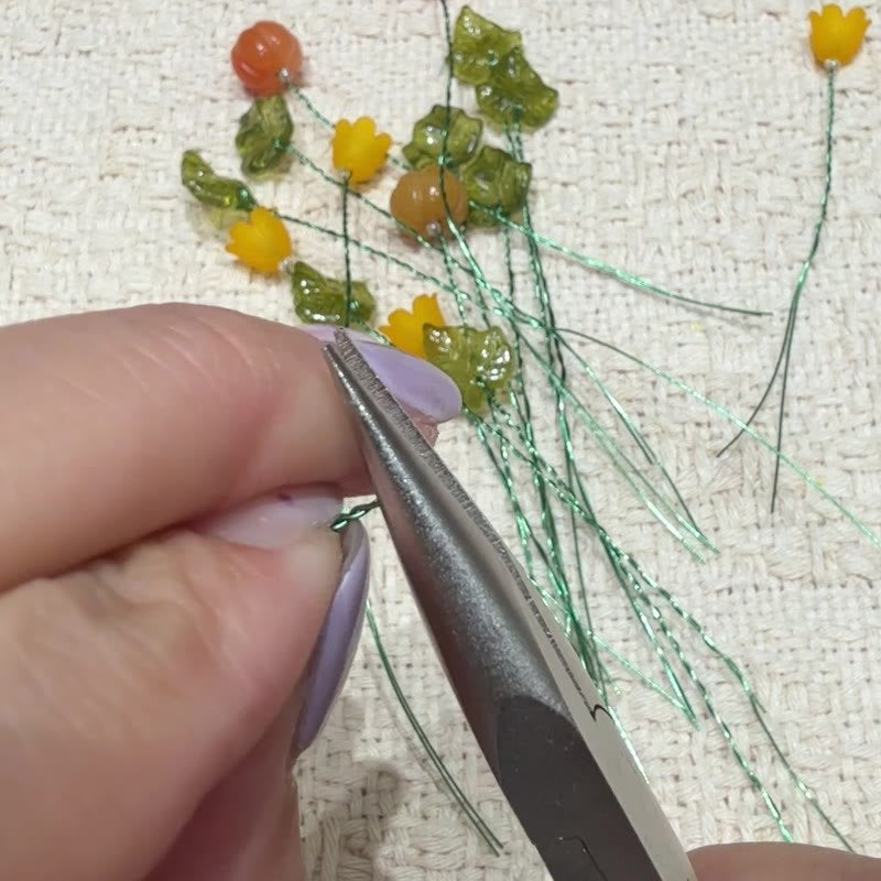 Pliers flattening the loop on the long wire.