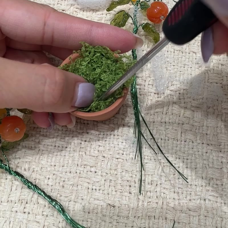 Green faux moss tucked inside the pot rim.