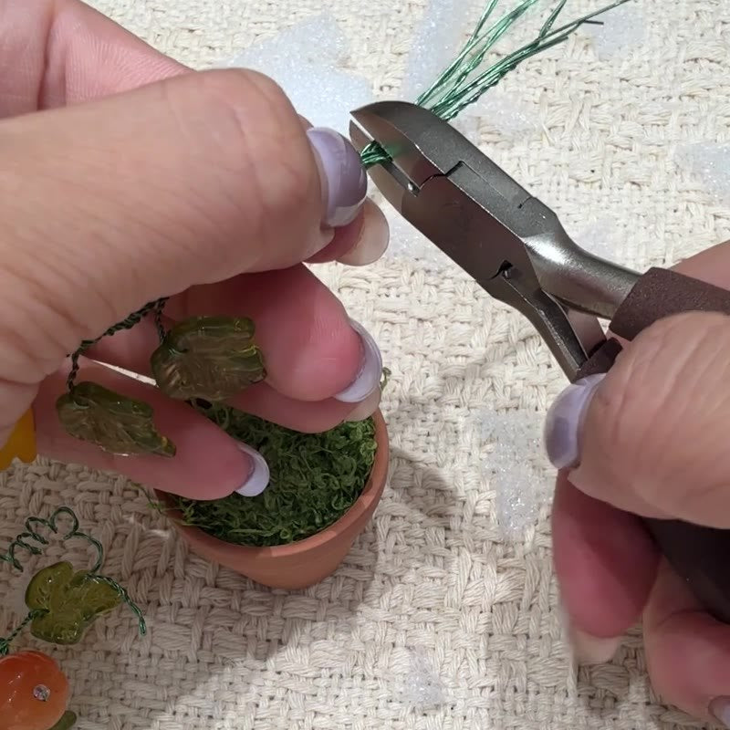 Wire cutters trimming the branch tails.