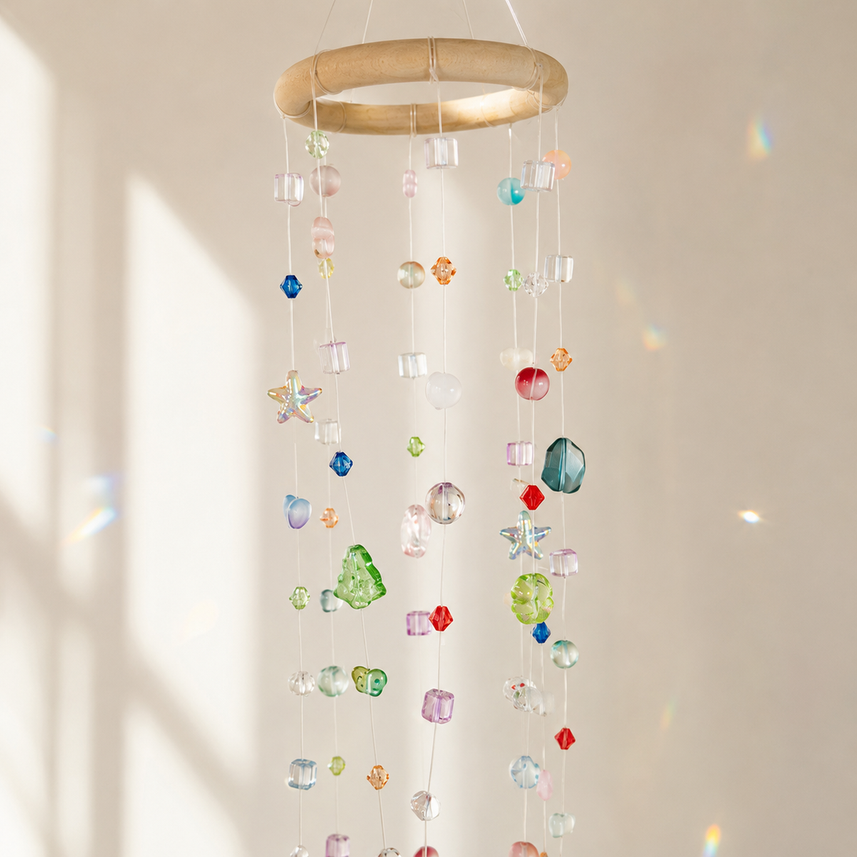 Close-up of mixed translucent beads and wrapped ring on a hanging mobile suncatcher